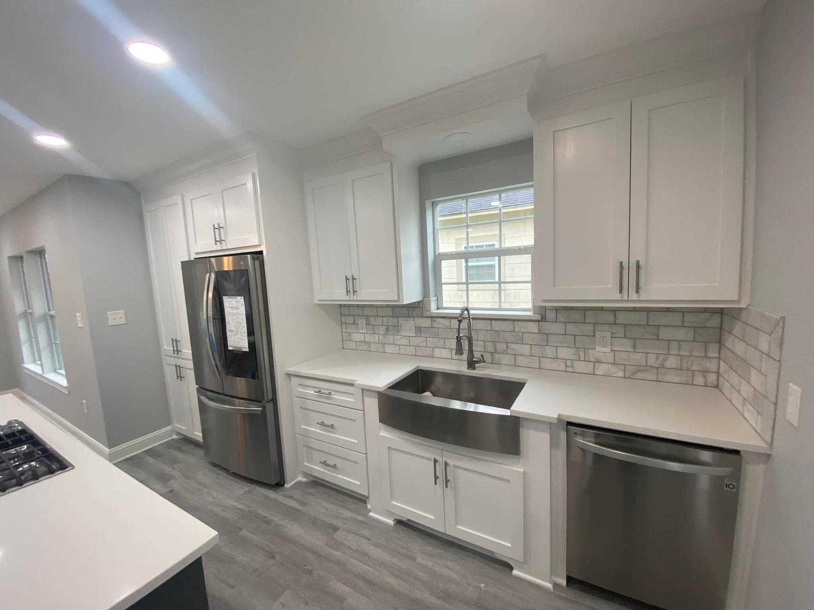 White shaker kitchen with farmhouse sink White shaker kitchen with stainless steel farmhouse sink and quartz countertops in Richmond TX