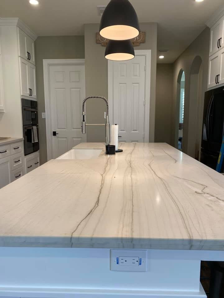 Quartzite waterfall island kitchen Large quartzite waterfall island with pendant lighting and shaker cabinetry in a Katy TX kitchen remodel