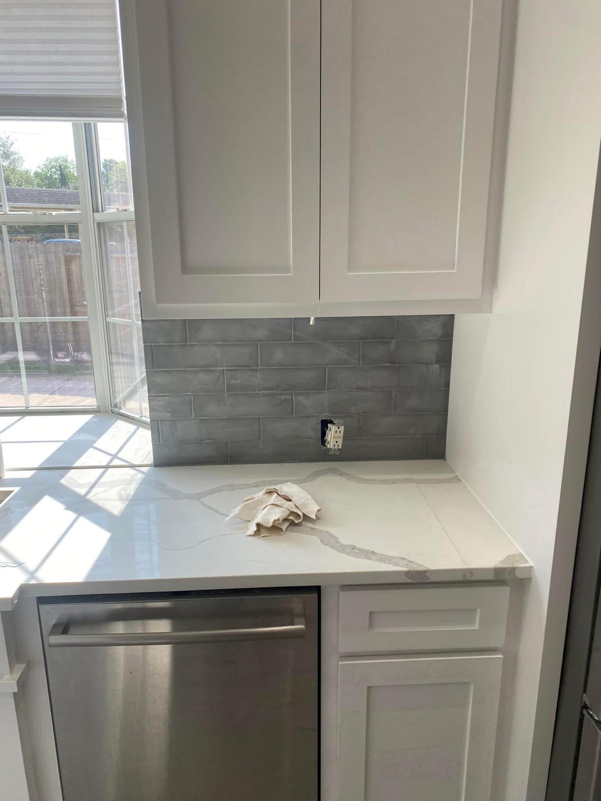 Kitchen with quartz counters and subway tile backsplash Kitchen remodel with quartz countertops and grey subway tile backsplash in Sugar Land TX