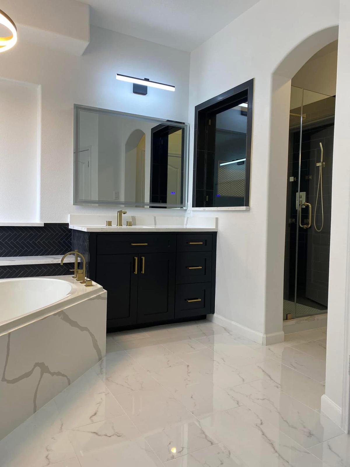 Modern black and gold master bath Luxury black vanity with gold hardware and white marble tub in a Katy TX master bathroom